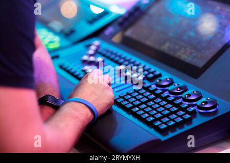 Opérateur de tableau d'éclairage travaillant sur la console de commande d'éclairage de scène. Mise au point sélective. Banque D'Images