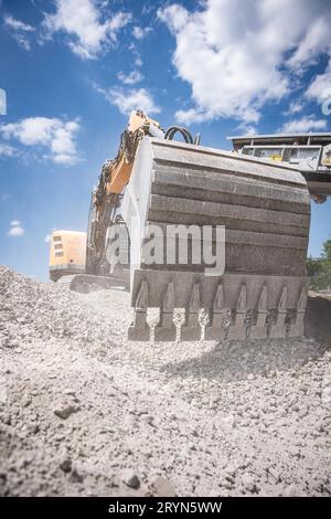 Pelle hydraulique à chenilles jaune avec grand godet pour recyclage de démolition sur chantier Banque D'Images