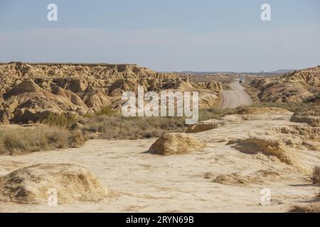 Route de gravier à travers le paysage désertique du plateau aride des Bardenas Reales, Arguedas, Navarre, Espagne Banque D'Images