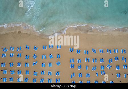 Drone aérienne de chaises de plage dans une plage de sable tropical. Vacances d'été en mer. Protaras Chypre. Banque D'Images