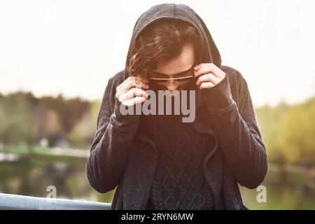 Homme à capuche se tient sur le pont et le gars porte des lunettes de soleil Banque D'Images