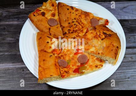 Fromage Fougasse recouvert de tranches de poivrons verts, de fromage et de saucisses coupées cuites au four, le pain de fougasse est un type de pain typiquement associé Banque D'Images