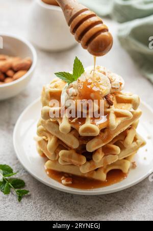 Gaufres belges avec fruits, bananes et miel. Cuisson maison. Concept de petits déjeuners sains. Banque D'Images