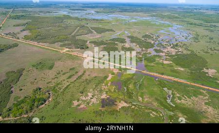 Vue aérienne de Transpantaneira traversée de route de terre dans le paysage typique des zones humides du Pantanal avec lagune Banque D'Images