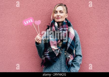 Jeune belle femme tient des accessoires amour.Saint-Valentin en février.Fond rose& Banque D'Images