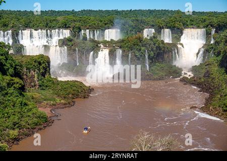 Vue sur la spectaculaire cascade des chutes d'Iguazu au soleil et rivière brune, Argentine Banque D'Images