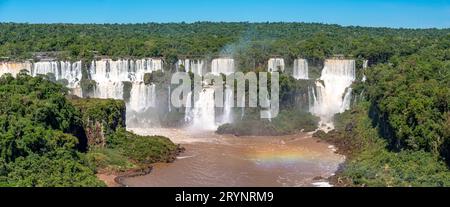 Vue panoramique de la cascade spectaculaire des chutes d'Iguazu au soleil et rivière brune, Argentine Banque D'Images