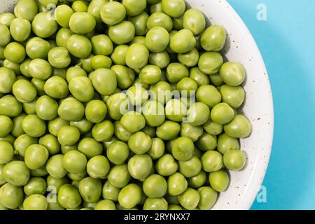 Gros plan de pois verts frais dans un bol Banque D'Images