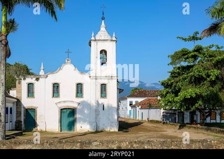 Église Nossa Senhora das Dores (notre Dame des Sorrows) avec deux palmiers par une journée ensoleillée, ville historique de Paraty, Brésil Banque D'Images