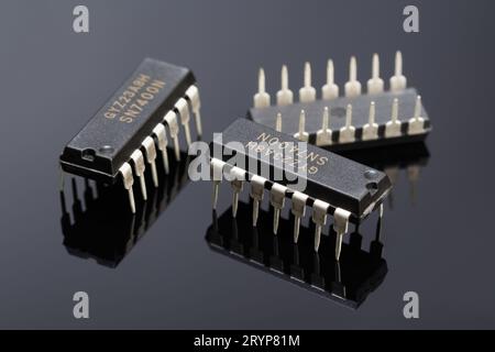 Trois puces logiques 7400 sur un fond sombre avec réflexion. Photographie macro Banque D'Images