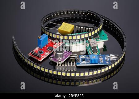 Divers modules supplémentaires et composants radio-électroniques pour Arduino sur fond sombre avec réflexion Banque D'Images