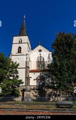 Eglise médiévale gothique de l'exaltation de la Sainte Croix avec tour au jour ensoleillé d'été, Fontaine dans le jardin du monastère, Sculpture chic. Litomysl, CZE Banque D'Images