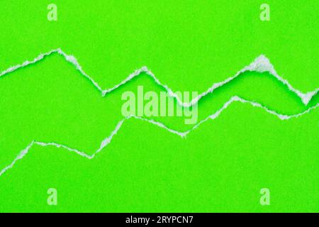 Trou déchiré dans un papier vert Banque D'Images