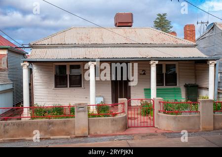 Un exemple d'un type d'architecture de maison propre à Broken Hill où la maison est revêtue de fer ondulé et la véranda avant est soutenue par quatre colonnes de style néo-classique. Une caractéristique est que beaucoup de maisons ont souvent l'unité de climatisation évaporative sur le toit en fer ondulé ; une idée très innovante au moment où ils ont été construits. Banque D'Images