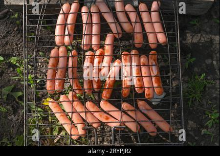 les saucisses sont frites sur le gril sur le gril. Banque D'Images