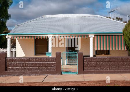 Un exemple d'un type d'architecture de maison propre à Broken Hill où la maison est revêtue de fer ondulé et la véranda avant est soutenue par quatre colonnes de style néo-classique. Une caractéristique est que beaucoup de maisons ont souvent l'unité de climatisation évaporative sur le toit en fer ondulé ; une idée très innovante au moment où ils ont été construits. Banque D'Images