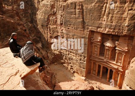 Bédouins assis au sommet d'une falaise à Petra, Jordanie Banque D'Images