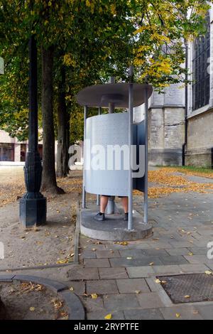 Homme utilisant un urinoir public gratuit dans le centre de Bruxelles, Belgique. Il est illégal d’uriner dans un espace public à Bruxelles. Banque D'Images
