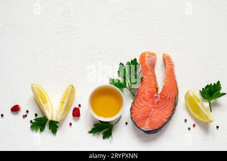 Steak de saumon cru frais, huile d'olive, citron et épices sur un b blanc Banque D'Images