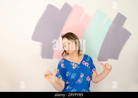 Femme animée dansant devant un mur coloré Banque D'Images