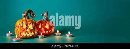 Bannière créative Halloween avec citrouilles en céramique diy Jack lanterne et bougies sur fond vert bleu Banque D'Images