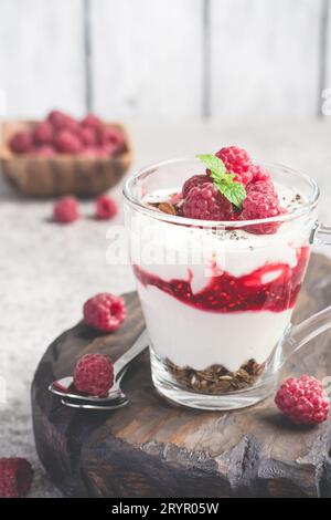 Dessert à la framboise ou petit déjeuner avec yaourt naturel dans une tasse en verre et framboises mûres Banque D'Images