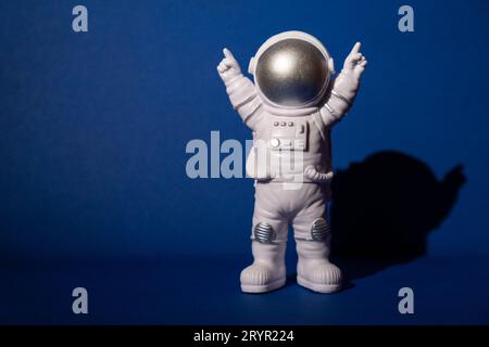 Astronaute jouet en plastique sur fond bleu coloré Copier l'espace. Concept de voyage hors de la terre, vol commercial privé d'homme spatial Banque D'Images