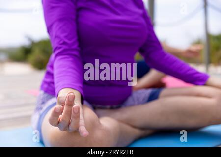 Section basse de femme âgée caucasienne méditant tout en pratiquant le yoga à la station touristique Banque D'Images