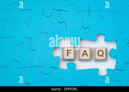 Message FAQ sur les touches du clavier de l'ordinateur placé parmi le puzzle bleu Banque D'Images