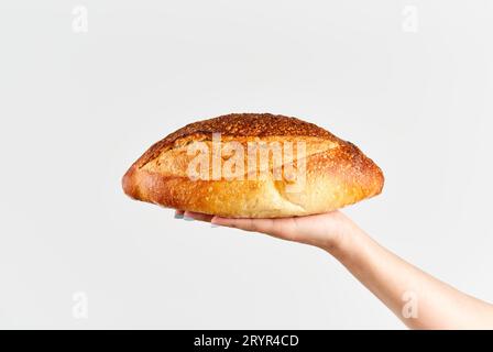 Pain multigrain maison dans la main de femme sur fond blanc Banque D'Images