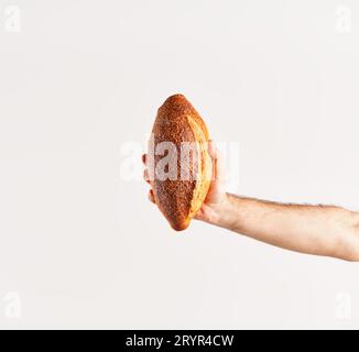 Pain multigrain maison dans la main de femme sur fond blanc Banque D'Images