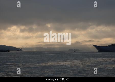 La beauté stupéfiante du port de Sydney tandis que la lumière du soleil traverse les berges de nuages bas, les ondulations de l'eau, les petits bateaux, la proue des navires, les bandes de terre Banque D'Images