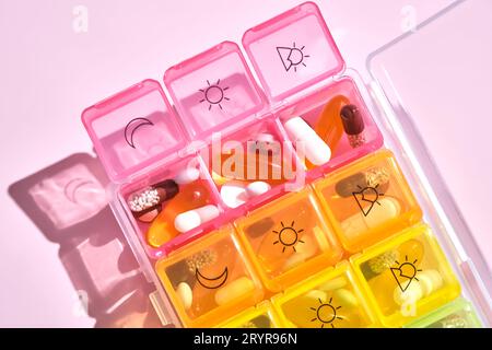 Boîte à pilules lumineuse avec différentes pilules et vitamines. Banque D'Images