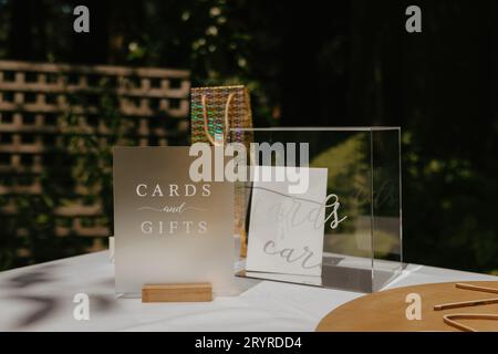 Un affichage vibrant de cartes et de cadeaux disposés sur une table en bois pour une cérémonie de mariage Banque D'Images