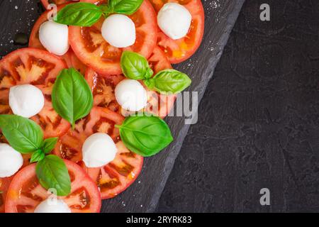 Salade caprese italienne fraîche sur assiette foncée. Vue de dessus avec copie s Banque D'Images
