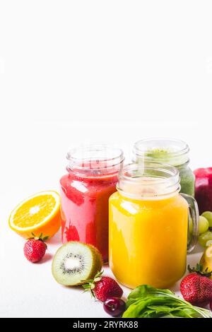 Sélection de smoothies aux fruits multicolores dans des bocaux en verre. Banque D'Images