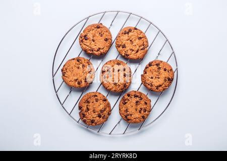 Biscuits aux pépites de chocolat d'avoine sur une grille ronde pour le refroidissement. Banque D'Images