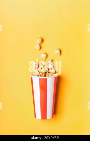 Pop-corn caramel doux dans une tasse rouge blanche rayée de papier Banque D'Images