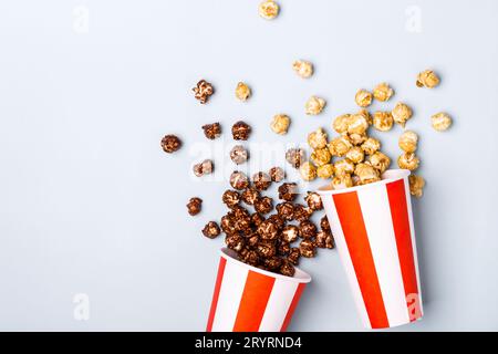 Pop-corn au chocolat caramel doux dans une tasse rouge blanche rayée de papier Banque D'Images