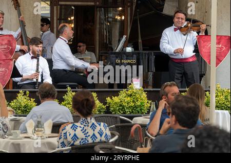 Un groupe se produit devant des clients assis au Caf Florian sur la Piazza San Marco, (place Saint-Marc) à Venise dans la région vénitienne du nord de l'Italie. Banque D'Images