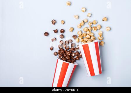Pop-corn au chocolat caramel doux dans une tasse rouge blanche rayée de papier Banque D'Images