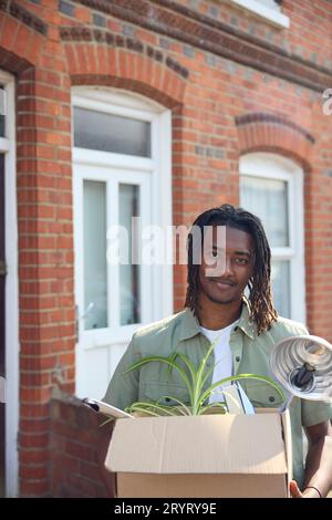 Portrait de jeune homme ou étudiant emménageant dans la maison appartement ou appartement tout en étudiant à l'université ou au collège Banque D'Images