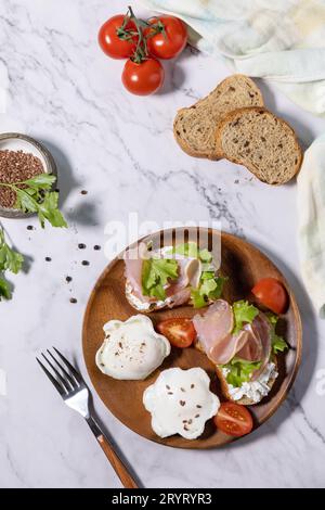 Petit déjeuner ou brunch de Pâques. Délicieux petit déjeuner ou collation - oeuf poché et fromage à la crème toast pain de seigle entier, prosciutto, Banque D'Images