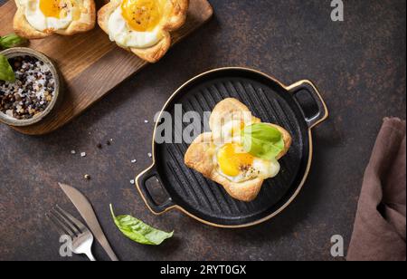 Idée petit déjeuner. Œufs brouillés en pâte feuilletée avec fromage et bacon sur une assiette en pierre. Vue d'en haut. Banque D'Images