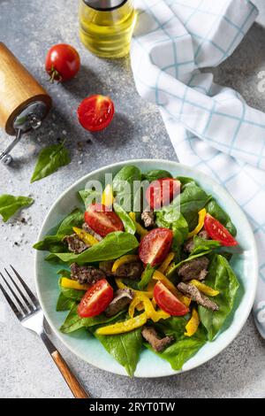 Salade chaude de jeunes épinards, foie de poulet, tomates et poivrons grillés avec épices et balsamique. Carb faible régime de céto sain. Banque D'Images