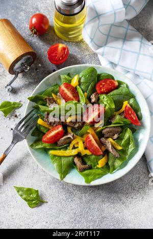 Salade tiède de jeunes épinards, foie de poulet, tomates et poivrons grillés aux épices et balsamique. Régime céto sain faible en glucides. C Banque D'Images