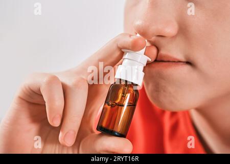 Blond Boy goutte des gouttes de nez du nez qui coule. Traitement des rhumes et rhinites allergiques. Mise au point sélective Banque D'Images