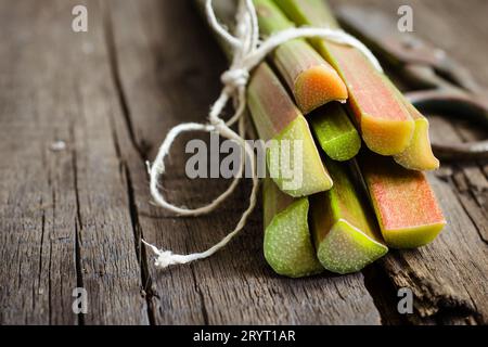 Tiges de rhubarbe fraîches sur fond de bois ancien Banque D'Images