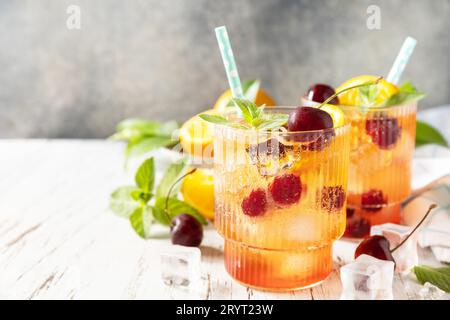 Boisson fraîche d'été. Boisson rafraîchissante glacée limonade de cola cerise orange ou cocktail mojito en verre sur une table en bois. Espace de copie Banque D'Images