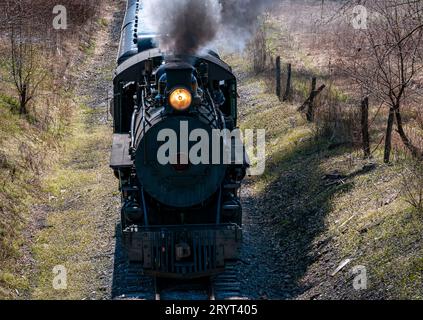 Une locomotive industrielle en mouvement, émettant un panache blanc de vapeur de sa cheminée Banque D'Images